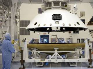 At the Payload Hazardous Servicing Facility at NASA's Kennedy Space Center in Florida, technicians, using an overhead crane, separate the two components of the aeroshell, an element of NASA's Mars Science Laboratory (MSL), after testing.