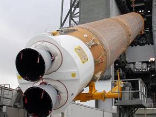 The first stage of the Atlas V rocket for NASA's Mars Science Laboratory (MSL) mission is lifted into an upright position for placement inside the Vertical Integration Facility at Space Launch Complex 41 on Cape Canaveral Air Force Station.