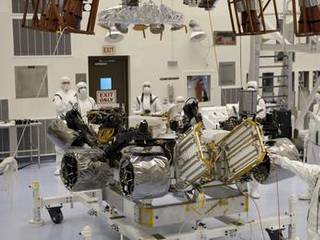 Under the watchful eyes of technicians at the Payload Hazardous Servicing Facility at NASA's Kennedy Space Center in Florida, an overhead crane lowers a rocket-powered descent stage over NASA's Mars Science Laboratory (MSL) rover, known as Curiosity, for integration.