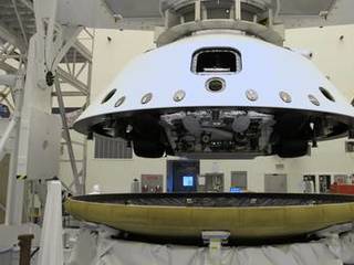 At the Payload Hazardous Servicing Facility at NASA's Kennedy Space Center in Florida, the "back shell powered descent vehicle" configuration, containing NASA's Mars Science Laboratory rover, Curiosity, is being placed on the spacecraft's heat shield.