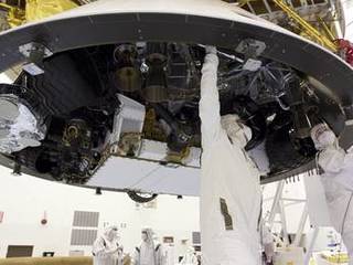 In the Payload Hazardous Servicing Facility at NASA's Kennedy Space Center in Florida, technicians work beneath NASA's Mars Science Laboratory (MSL) mission aeroshell, (containing the compact car-sized rover Curiosity), which has been mated to the cruise stage.