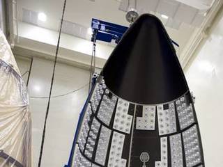 In the Payload Hazardous Servicing Facility at NASA's Kennedy Space Center in Florida, a section of the Atlas V payload fairing for NASA's Mars Science Laboratory (MSL) mission hangs vertically from the ceiling.