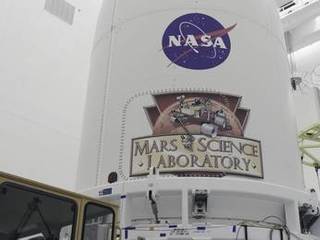 In the Payload Hazardous Servicing Facility at NASA's Kennedy Space Center in Florida, the Atlas V rocket's payload fairing containing the Mars Science Laboratory (MSL) spacecraft stands securely atop the transporter that will carry it to Space Launch Complex 41.