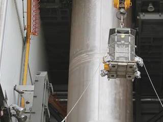 Enclosed in the protective mesh container known as the "gorilla cage," the multi-mission radioisotope thermoelectric generator (MMRTG) for NASA's Mars Science Laboratory (MSL) mission is lifted up the side of the Vertical Integration Facility at Space Launch Complex 41.