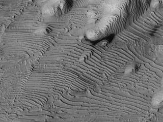 Rhythmic patterns of sedimentary layering in Danielson Crater on Mars result from periodic changes in climate related to changes in tilt of the planet.
