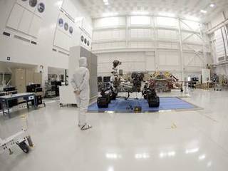 An engineer says goodbye to the Curiosity rover and its powered descent vehicle in the Jet Propulsion Laboratory's Spacecraft Assembly Facility shortly before the spacecraft was readied for shipment to Kennedy Space Center for launch.