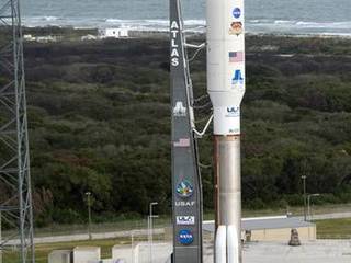 On Cape Canaveral Air Force Station in Florida, the 197-foot-tall United Launch Alliance Atlas V rocket arrives on the launch pad at Space Launch Complex-41, situated near the Atlantic Ocean.