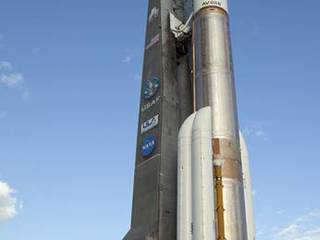 On Cape Canaveral Air Force Station in Florida, the 197-foot-tall United Launch Alliance Atlas V rocket is backdropped by a bright blue sky as the vehicle rolls from the Vertical Integration Facility (VIF) to the launch pad at Space Launch Complex 41.