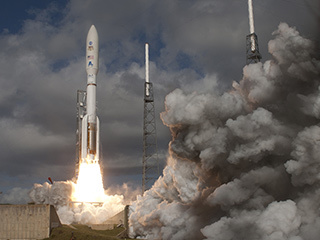 With NASA's Mars Science Laboratory (MSL) spacecraft sealed inside its payload fairing, the United Launch Alliance Atlas V rocket rides smoke and flames as it rises from the launch pad at Space Launch Complex-41 on Cape Canaveral Air Force Station in Florida at 10:02 a.m. EST Nov. 26.