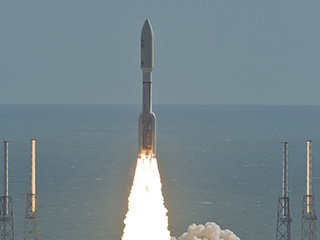 With NASA's Mars Science Laboratory (MSL) spacecraft sealed inside its payload fairing, the United Launch Alliance Atlas V rocket rides smoke and flames as it rises from the launch pad at Space Launch Complex-41 on Cape Canaveral Air Force Station in Florida at 10:02 a.m. EST Nov. 26.