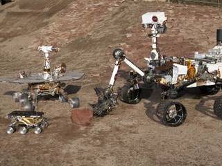 This grouping of two test rovers and a flight spare provides a graphic comparison of three generations of Mars rovers developed at NASA's Jet Propulsion Laboratory, Pasadena, Calif. The setting is JPL's Mars Yard testing area.