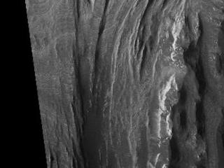 This HiRISE image shows a portion of interior layered deposits (ILD) in Juventae Chasma. Juventae Chasma is a large depression near the equatorial canyon system Valles Marineris. The scene is along the top of a mound of layered deposits on the floor of Juventae Chasma. Dunes are seen in the low-lying, darker regions. Very fine layers are also seen (see subimage, approximately 1 km across). Understanding what kinds of materials formed the layers, how they were set in place, and how they have evolved will provide insight into Martian geologic history.