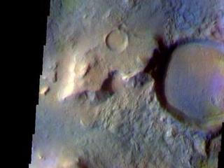 This false color image shows a region with craters of different ages located at the margin of Acidalia Planitia. This image was collected during the Northern Spring season. The THEMIS VIS camera is capable of capturing color images of the Martian surface using five different color filters. In this mode of operation, the spatial resolution and coverage of the image must be reduced to accommodate the additional data volume produced from using multiple filters. To make a color image, three of the five filter images (each in grayscale) are selected. Each is contrast enhanced and then converted to a red, green, or blue intensity image. These three images are then combined to produce a full color, single image. Because the THEMIS color filters don't span the full range of colors seen by the human eye, a color THEMIS image does not represent true color. Also, because each single-filter image is contrast enhanced before inclusion in the three-color image, the apparent color variation of the scene is exaggerated. Nevertheless, the color variation that does appear is representative of some change in color, however subtle, in the actual scene. Note that the long edges of THEMIS color images typically contain color artifacts that do not represent surface variation.