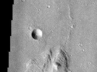 This lunar-like scene occurs along the southeastern rim of the Isidis Planitia basin. The Isidis basin is an ancient impact crater some 1200 km across that is found along the boundary separating the heavily-cratered southern highland terrain of Mars from the northern lowlands. Elements of both terrains are evident in this image as an island of rugged highland terrain surrounded by smoother lowland terrain. The resurfacing of the Isidis basin produced a system of wrinkle ridges, some of which are seen on the lowland terrain in the image. Wrinkle ridges are a common feature on the surface of the moon and add to the lunar-like quality of this image. Layers are visible in the large island, the most resistant of which likely are from lava flows that created the highland terrain. The process by which the global-scale highland/lowland dichotomy was created remains a mystery.