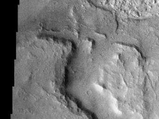 The floor of this crater in Terra Sirenum contains layered material. The layered sedimentary material on Mars is arguably the most interesting and compelling material on the planet. These layers most likely contain the answers to fundamental questions about Martian geology, climate, and possibly even biology.