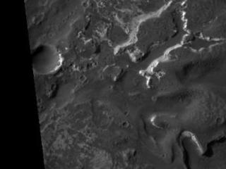 This HiRISE image covers the southwest portion of the terraces and floor of Holden Crater situated in southwest Margaritifer Terra. The HiRISE sub-frame shows the most clearly-evident image of a megabreccia on Mars. Breccia is a rock typically consisting of rock fragments of various sizes and shapes that have been broken, tumbled and cemented together in sudden geologic event (e.g., a landslide, a flashflood or even an impact-cratering event). If it were not for the dark sandy dunes dispersed through out the sub-image, this image could easily fool an expert into thinking that this image is actually a photograph of a hand sample of an impact breccia. The prefix "mega" implies that the breccia in the sub-image consists of clasts, or rock fragments, that are typically larger than a large house or a building. The rectangular megaclast near the center of the image is a colossal 50 x 25 meters (~150 X 75 feet). As mentioned in the transition image caption for Holden crater (TRA_000861_1530), the crater likely experienced extensive modification by running water, which is supported by observations of drainage and deposition into the crater from a large channel (Uzboi Valles) breaching Holden's southwest rim. While it is possible that the megabreccia formed from a catastrophic release of water into the crater, a more likely possibility is that it formed from the impact that created the approx. 150 km-in-diameter Holden crater. Popigai Crater, a terrestrial crater of half the size of Holden, possesses a similar occurrence of megabreccia with a similar range in megaclast size to the Holden crater example. An impact-generated megabreccia deposit, as observed in terrestrial craters, typically lies beneath the crater floor, so the exhumation of the megabreccia may be the result of down-cutting and erosion of water that once flowed through Uzboi Valles.