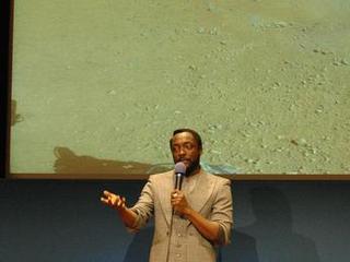 Musician will.i.am addresses a crowd of students at JPL during an event celebrating the first time in history that a recorded song has been beamed back to Earth from another planet.