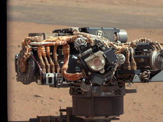 This image shows the Mars Hand Lens Imager (MAHLI) on NASA's Curiosity rover, with the Martian landscape in the background.