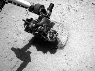 This image shows the robotic arm of NASA's Mars rover Curiosity with the first rock touched by an instrument on the arm.