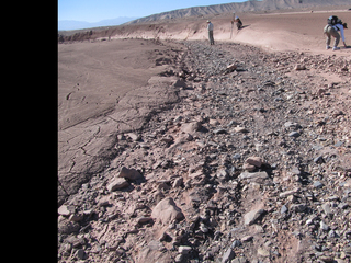 This image shows a dry streambed on an alluvial fan in the Atacama Desert, Chile, revealing the typical patchy, heterogeneous mixture of grain sizes deposited together.