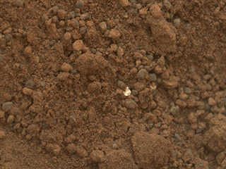This image shows part of the small pit or bite created when NASA's Mars rover Curiosity collected its second scoop of Martian soil at a sandy patch called "Rocknest."