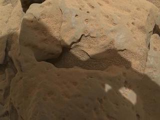 This focus-merge image from the Mars Hand Lens Imager (MAHLI) on the arm of NASA's Mars rover Curiosity shows a rock called "Burwash." The rock has a coating of dust on it. The coarser, visible grains are windblown sand.