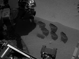 NASA's Mars rover Curiosity used a mechanism on its robotic arm to dig up five scoopfuls of material from a patch of dusty sand called "Rocknest," producing the five bite-mark pits visible in this image from the rover's left Navigation Camera (Navcam).