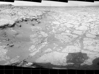 In a shallow depression called "Yellowknife Bay," the NASA Mars rover Curiosity drove to an edge of the feature during the 130th Martian day, or sol, of the mission (Dec. 17, 2012) and used its Navigation Camera to record this view of the ledge at the margin and a view across the "bay."