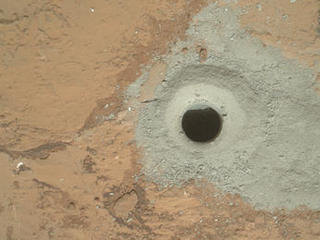 At the center of this image from NASA's Curiosity rover is the hole in a rock called "John Klein" where the rover conducted its first sample drilling on Mars.