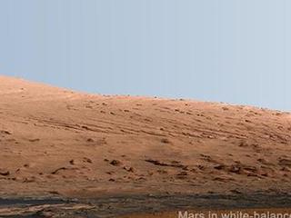 This mosaic of images from the Mast Camera (Mastcam) on NASA's Mars rover Curiosity shows Mount Sharp in a white-balanced color adjustment that makes the sky look overly blue but shows the terrain as if under Earth-like lighting.