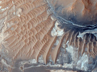 This image reveals exposed layers in Noctis Labyrinthus which may contain signatures of iron bearing sulfates and phyllosilcate (clay) minerals.