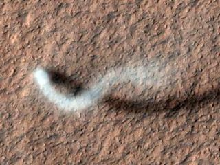 A towering dust devil casts a serpentine shadow over the Martian surface in this image acquired by the High Resolution Imaging Science Experiment (HiRISE) camera on NASA's Mars Reconnaissance Orbiter.