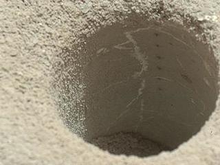 The hole that NASA's Curiosity Mars rover drilled into target rock "John Klein" provided a view into the interior of the rock, as well as obtaining a sample of powdered material from the rock.