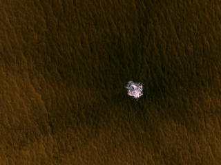 A meteorite impact that excavated this crater on Mars exposed bright ice that had been hidden just beneath the surface at this location.