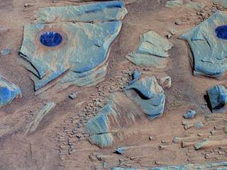 Spirit acquired this false-color image after using the rock abrasion tool to brush the surfaces of rock targets informally named "Stars" (left) and "Crawfords" (right). Small streaks of dust extend for several centimeters behind the small rock chips and pebbles in the dusty, red soils. Because the rover was looking southwest when this image was taken, the wind streaks indicate that the dominant wind direction was from the southeast.