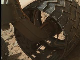 The left-front wheel of NASA's Curiosity Mars rover shows dents and holes in this image taken during the 469th Martian day, or sol, of the rover's work on Mars (Nov. 30, 2013).