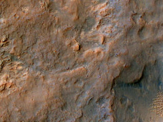 Two parallel tracks left by the wheels of NASA's Curiosity Mars rover cross rugged ground in this portion of a Dec. 11, 2013, observation by the High Resolution Imaging Science Experiment (HiRISE) camera on NASA's Mars Reconnaissance Orbiter.