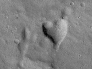 This picture of a heart-shaped pit was taken on 26 February 2008 by the CTX camera aboard MRO. It is approximately 2 km long. The pit is one of many adjacent to Hydaspis Chaos, a jumbled topographic depression thought to have formed by collapse of the surface due to-perhaps-catastrophic release of groundwater.