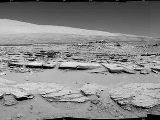 A landscape scene from NASA's Curiosity Mars rover shows rock rows at "Junda" forming striations in the foreground, with Mount Sharp on the horizon. The component images were taken by the rover's Navigation Camera (Navcam), looking southward, during a pause in driving on Feb. 19.