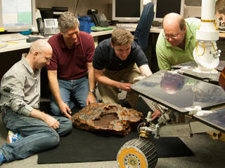 Researcher Kris Capraro adds the finishing touches of realistic color to a model of the "Block Island" meteorite.