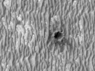 This image shows NASA's Mars Exploration Rover Opportunity perched on the edge of "Concepción" crater in Meridiani Planum, Mars.