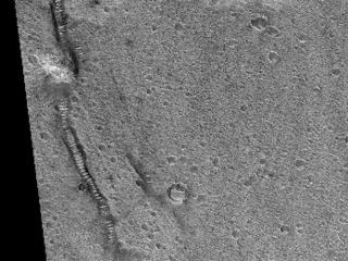 This image shows part of the surface of Chryse Planitia, near the mouth of several of the giant outflow channels carved by massive floods. At this location the channel is much too large to be seen within a HiRISE image, and this shows an area of level plains near the mouth.