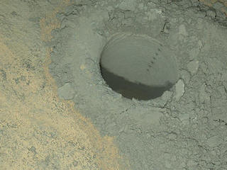 The Mars Hand Lens Imager on NASA's Curiosity Mars rover provided this nighttime view of a hole produced by the rover's drill and, inside the hole, a line of scars produced by the rover's rock-zapping laser.  The camera used its own white-light LEDs to illuminate the scene on May 13, 2014.