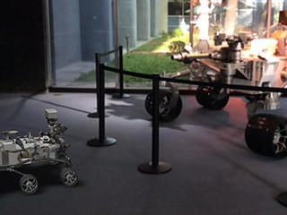 A 3D, augmented reality model of NASA's Curiosity rover shares a scene with a real life model of the rover in a view taken with NASA's Spacecraft 3D app.