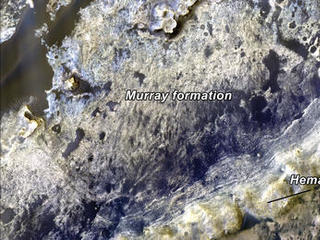 This color image shows the transition between the "Murray Formation,"  and the hematite ridge, which is made up of continuous layers that can be traced laterally for hundreds of meters.  Between both areas is a dark band of material, which are the dunes that divide Murray Ridge and Hematite Ridge.