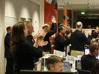 This image shows about 20 people wearing black shirts and mic headset clapping to celebrate MAVEN's arrival at Mars.