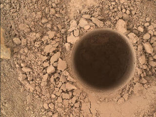 This image from the Mars Hand Lens Imager (MAHLI) camera on NASA's Curiosity Mars rover shows the first sample-collection hole drilled in Mount Sharp, the layered mountain that is the science destination of the rover's extended mission.