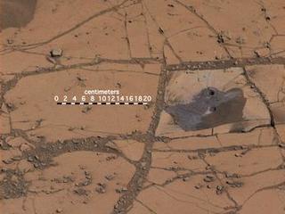 This image shows the first holes drilled by NASA's Mars rover Curiosity at Mount Sharp. The loose material near the drill holes is drill tailings and an accumulation of dust that slid down the rock during drilling.