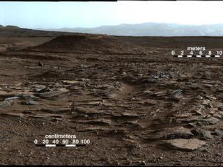 This April 4, 2014, image from Curiosity's Mastcam looks to the west of a waypoint on the rover's route to Mount Sharp. The mountain lies to the left of the scene. The image shows sets of sandstone beds inclined to the south (left), indicating progressive build-out of sediment toward Mount Sharp.