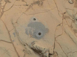 Gray cuttings from Curiosity's drilling into a target called "Mohave 2" are visible surrounding the sample-collection hole in this Jan. 31, 2015, image from the rover's MAHLI camera. This site in the "Pahrump Hills" outcrop provided the mission's second drilled sample of Mars' Mount Sharp.